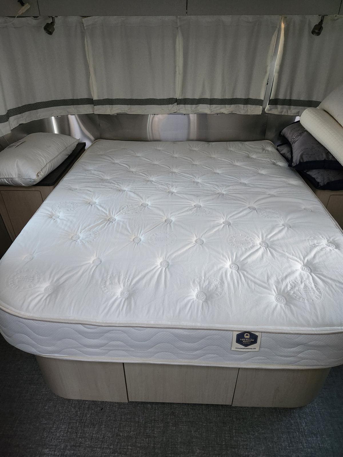 Queen mattress in an Airstream bedroom with storage drawers below
