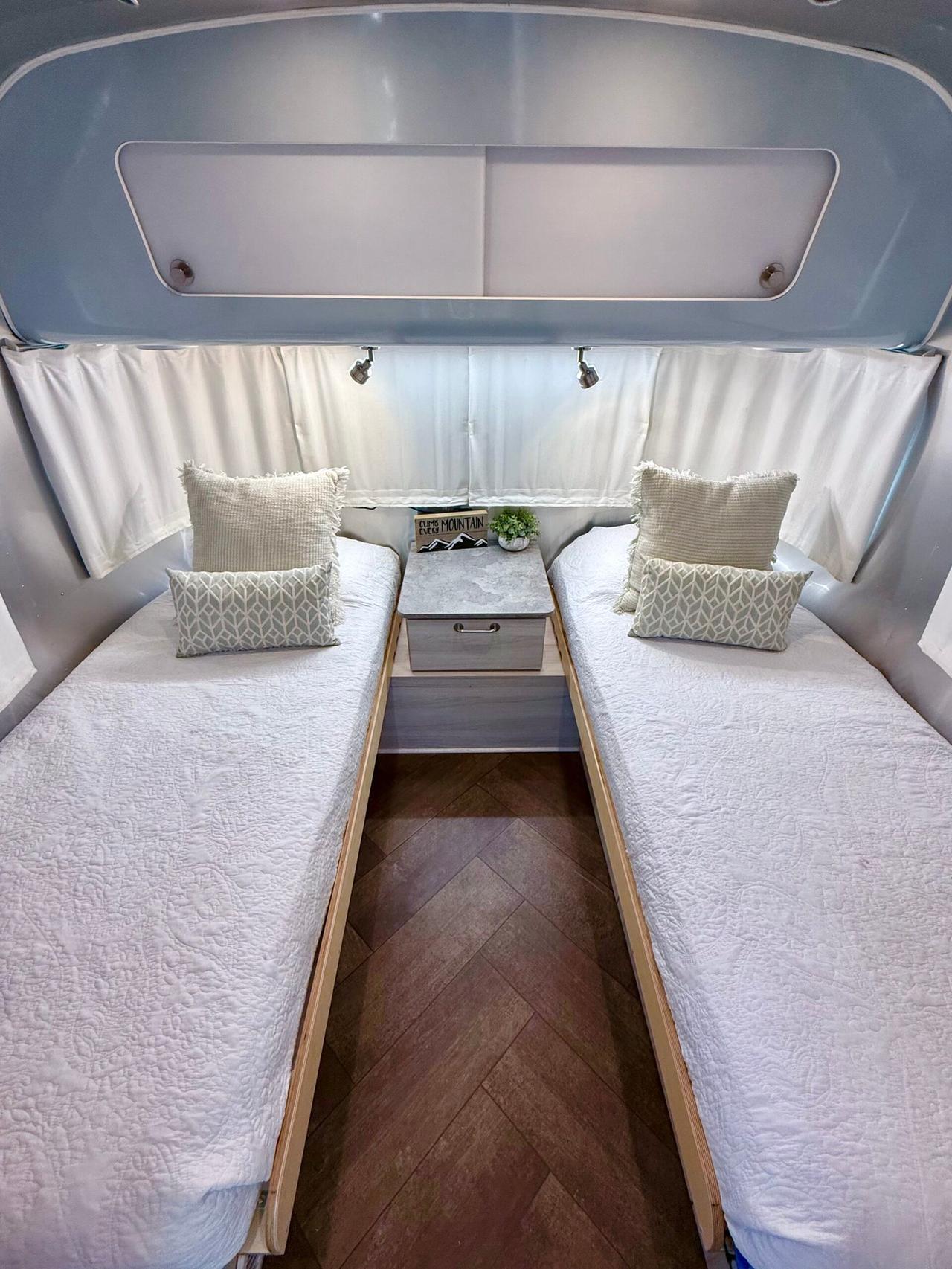 Airstream bedroom with two twin beds made up in white quilts and pillows